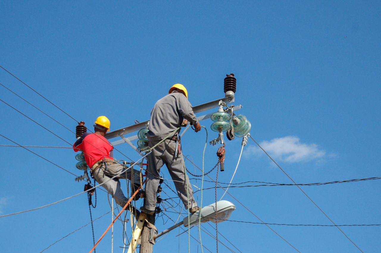 Low angle shot of electric linemen working on pole Low angle shot of electric linemen working on pole